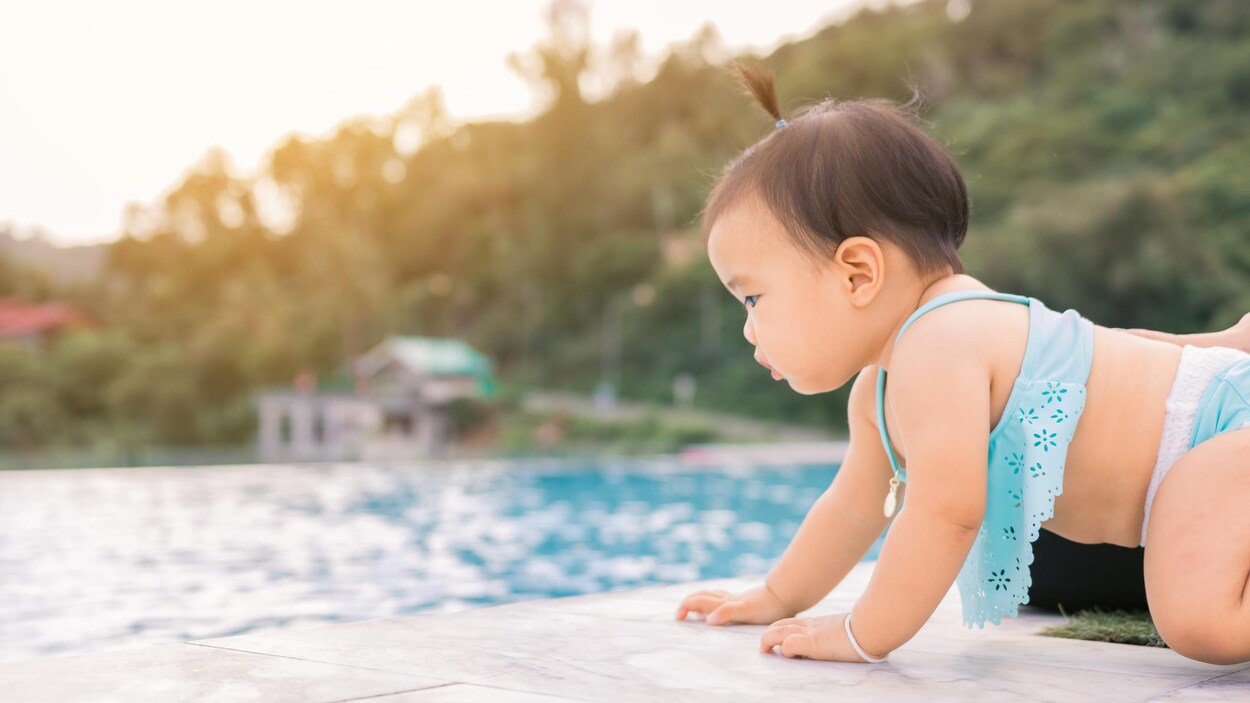 Un bébé s'approche dangereusement d'une piscine en rampant.