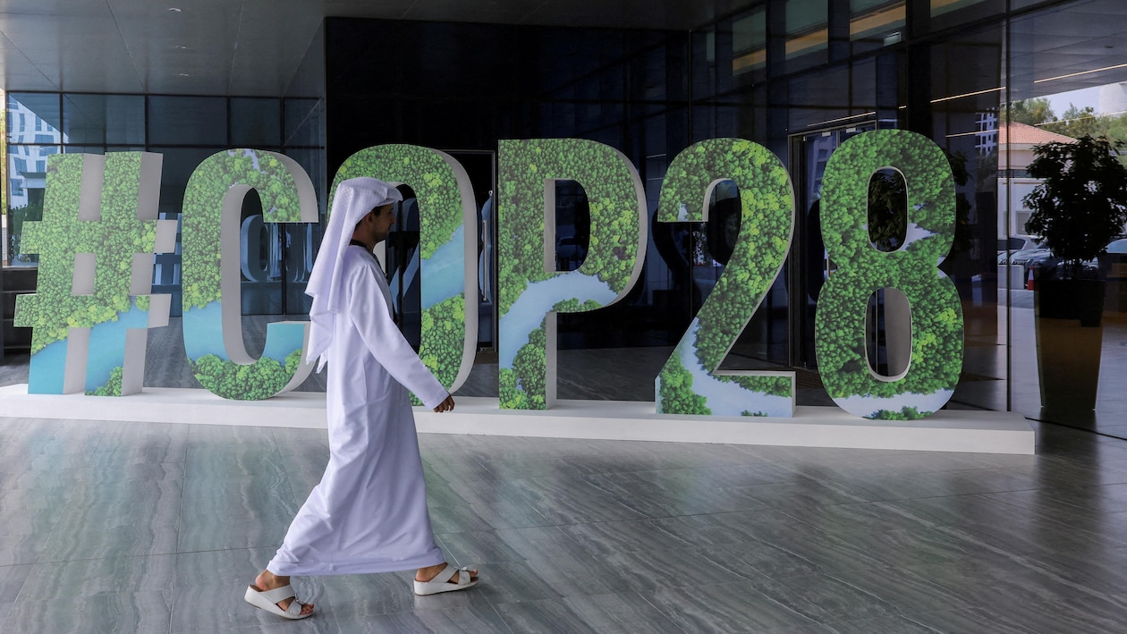  Une personne passe devant un panneau "#COP28" lors du Changemaker Majlis, un atelier de réflexion d'une journée destiné aux dirigeants d'entreprise et axé sur l'action climatique, à Abou Dhabi.