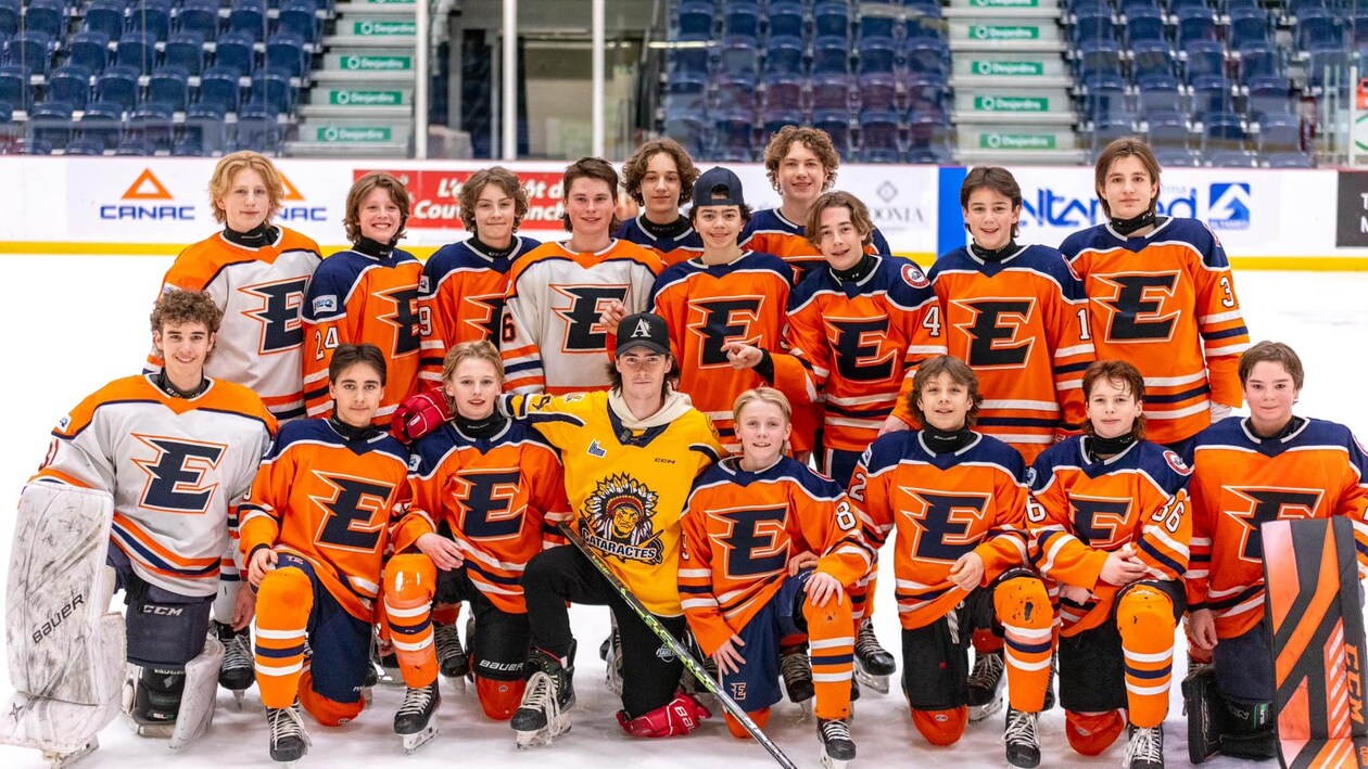 Des jeunes joueurs de hockey placé pour prendre une photo d'équipe.