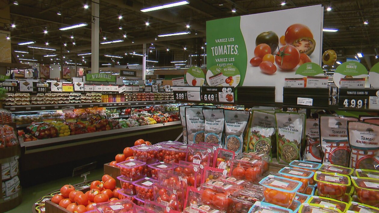 Des comptoirs de fruits et légumes dans un supermarché.
