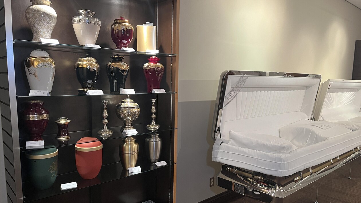 Des urnes vides sur des tablettes dans une salle de montre d'une résidence funéraire.