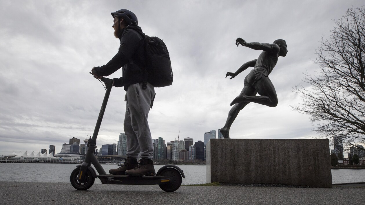 Une personne sur une trottinette électrique dans Vancouver