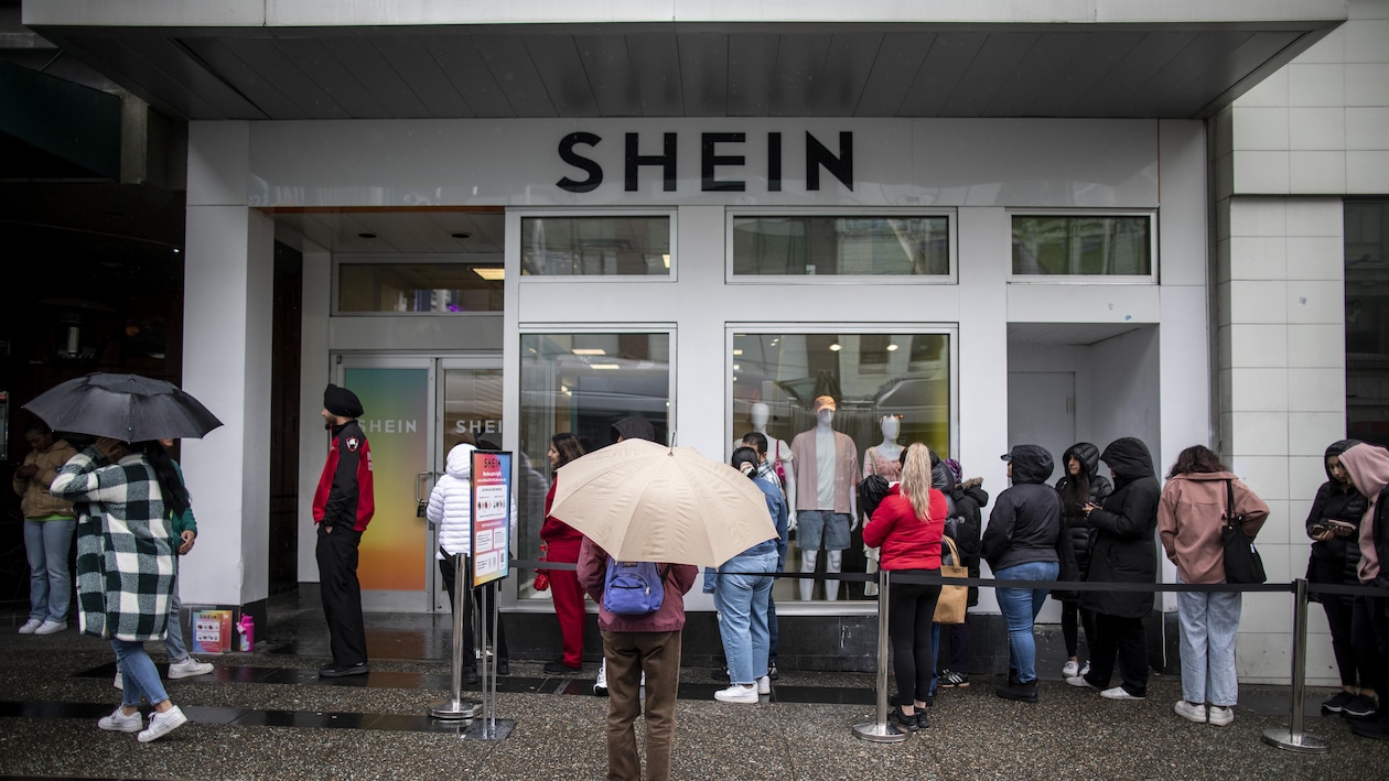 Des gens font la file sous la pluie devant une boutique temporaire de l'entreprise Shein à Vancouver, le 11 avril. 