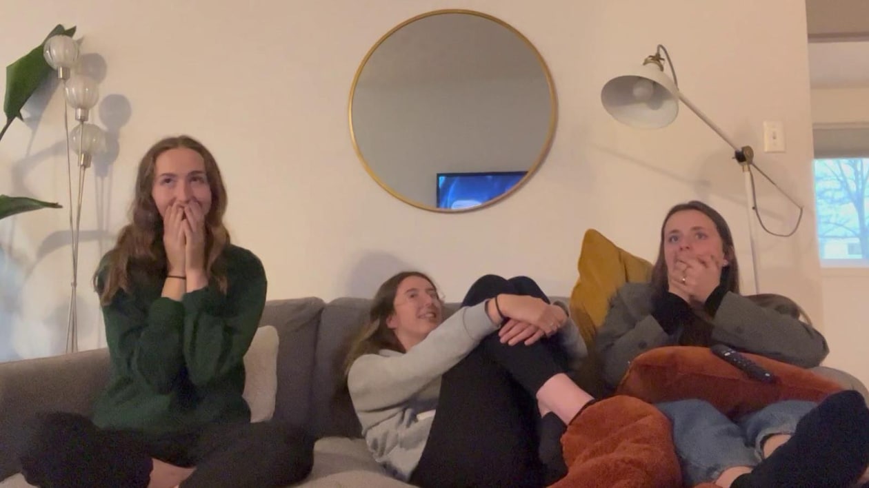 Trois personnes sur un sofa qui semblent surprises.