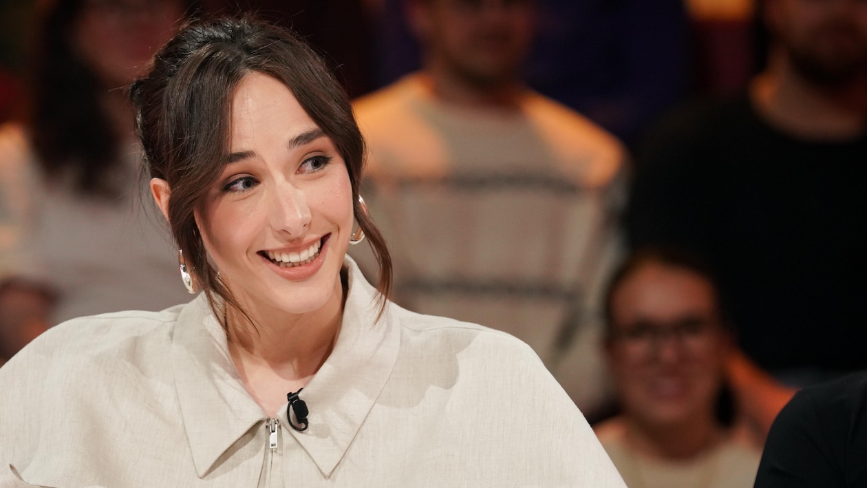 Ariane Roy est assise dans le studio.