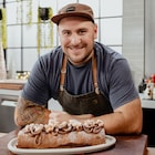 Il présente sa buche au chocolat.