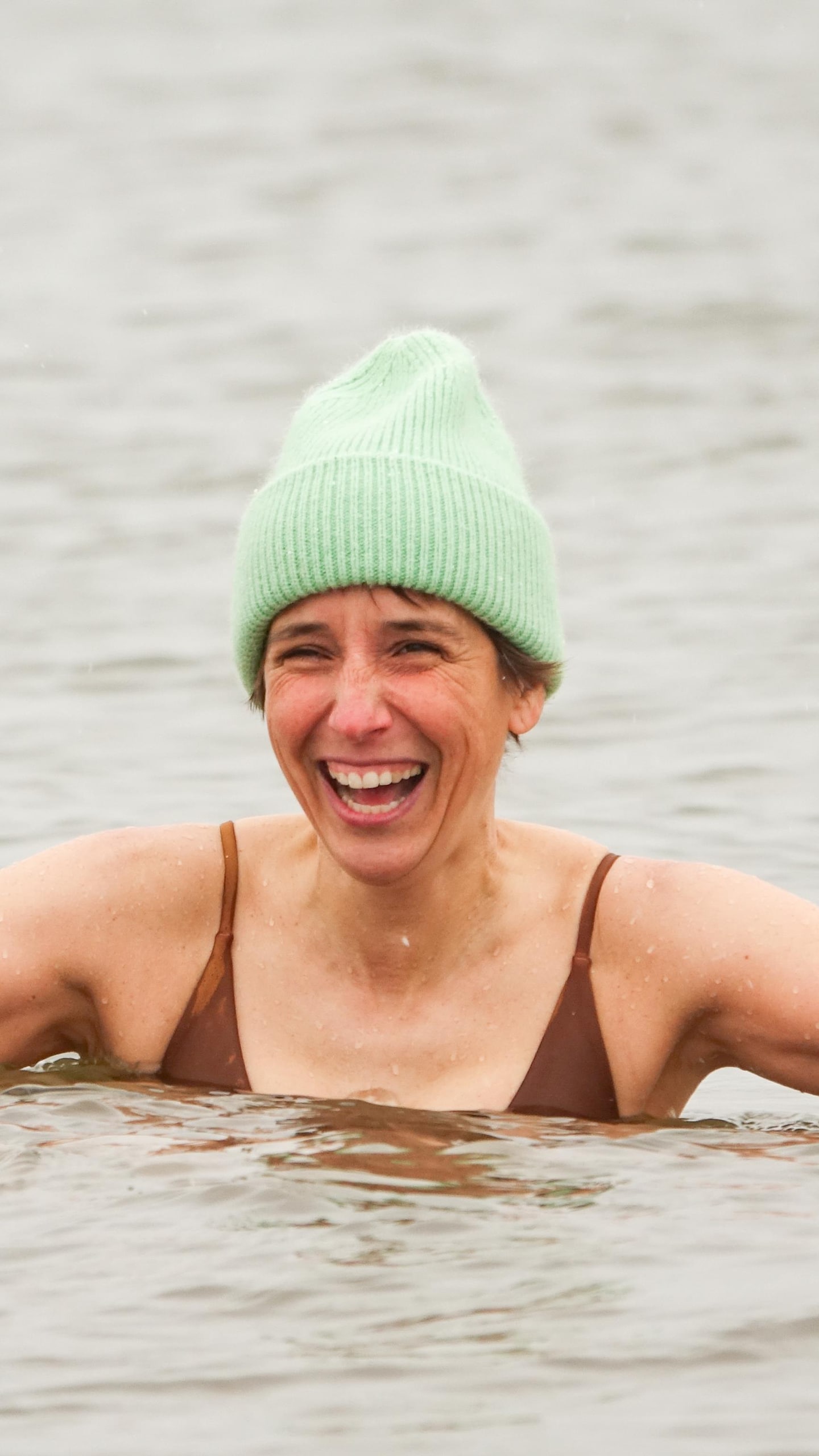 Pauline-Gervaise sourit en se baignant, avec une tuque sur la tête.