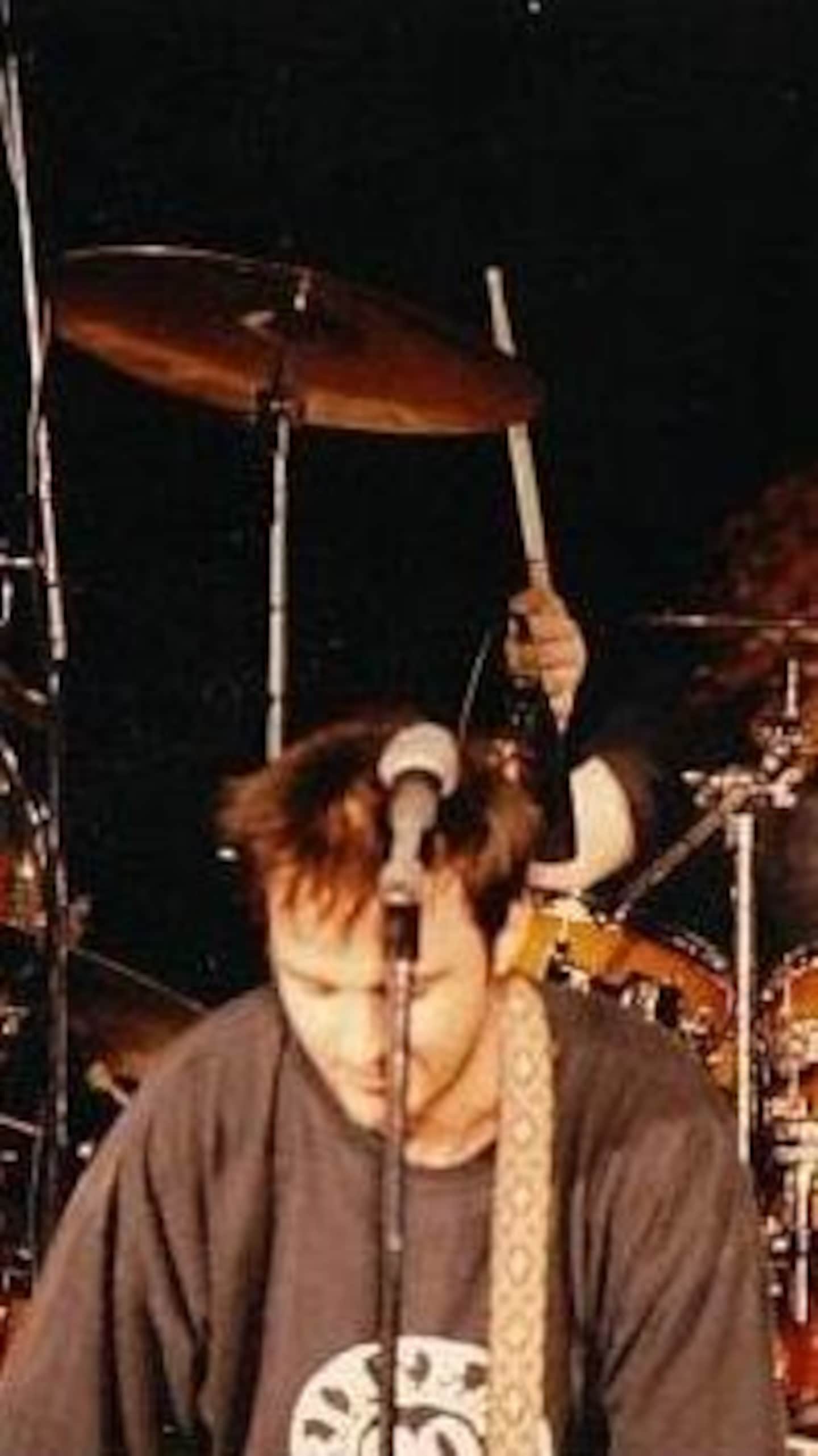 Un batteur et un chanteur sur scène.
