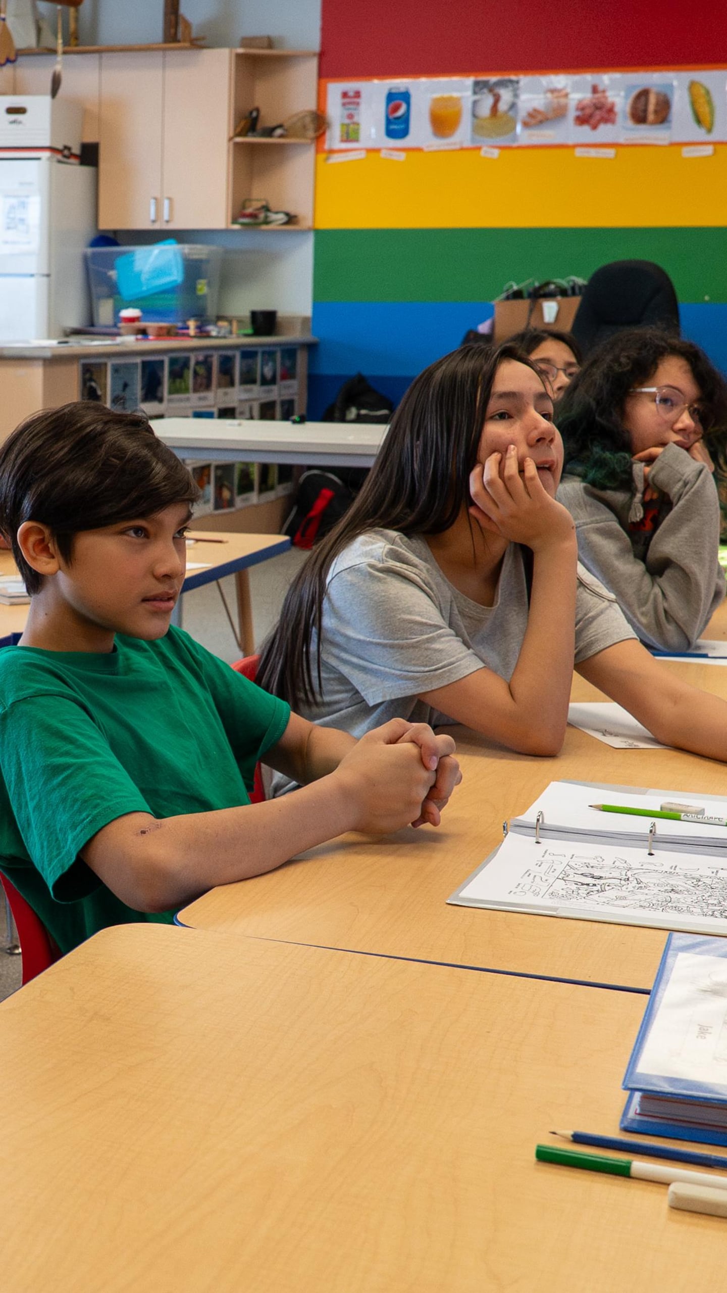 Huit élèves de 6e année écoutent attentivement en classe.