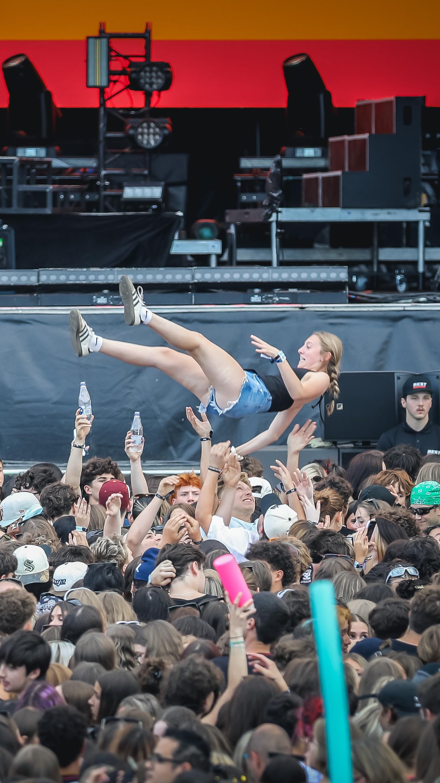 Des gens dans la foule sur les plaines d'Abraham soulevant une jeune femme dans les airs.