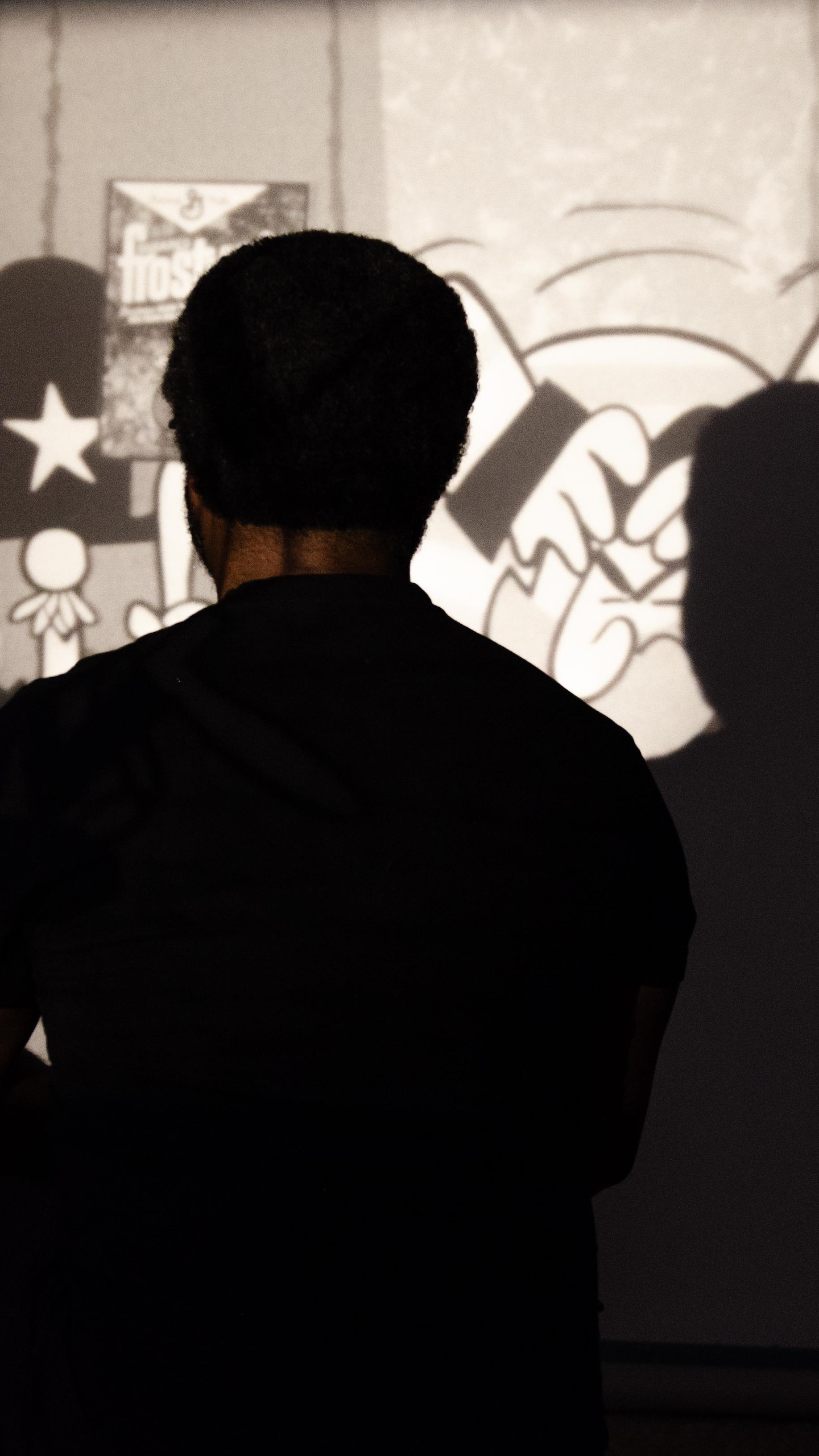 Les lumières éteintes, Elyas Tesfaye regarde une animation dans son sous-sol, à Winnipeg, en juillet 2026.