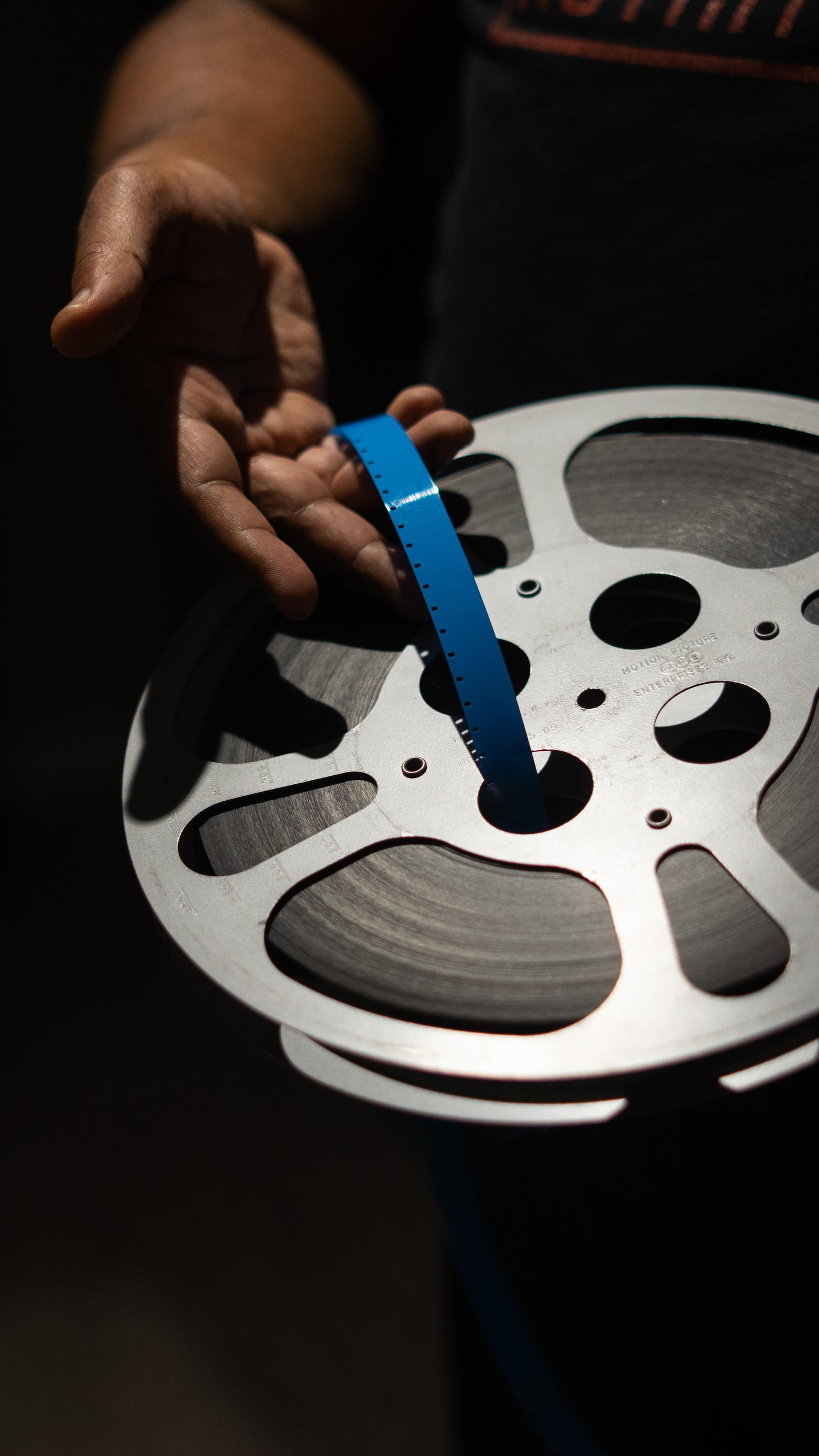 Une bobine de film entre les mains de Elyas Tesfaye, à Winnipeg, en juillet 2026.