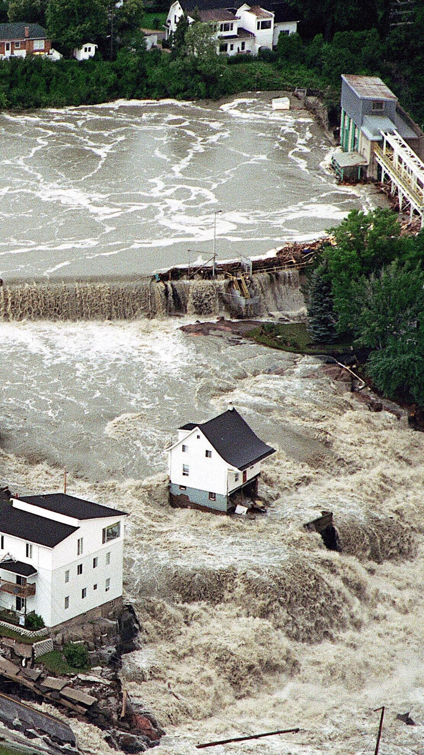 Des bâtiments envahis par des torrents d'eau, à Saguenay en 1996.