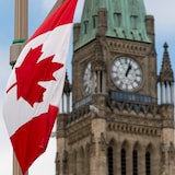 Un drapeau du Canada flottant sur la colline du Parlement d'Ottawa.