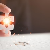 une femme tenant une pièce de puzzle.