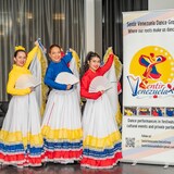 Femmes en costumes folkloriques jaunes, bleus et rouges représentant le Venezuela.