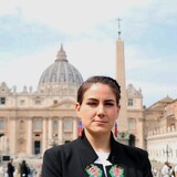 Une femme se tient debout sur la place Saint-Pierre, au Vatican.