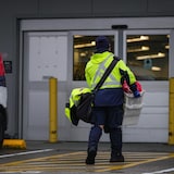 Une personne qui travaille à Postes Canada retourne travailler à un entrepôt de Vancouver, le 17 décembre 2024.