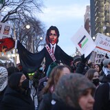 Mga taong nagpoprotesta na may hawak na effigy ni Trudeau, banners at watawat ng Palestine.