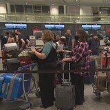 مسافرون يقفون في طوابير أمام نقاط تسجيل الأمتعة في مطار بيار إليوت ترودو الدولي في مونتريال.