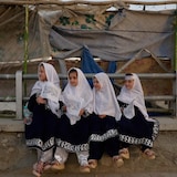 Four young girls dressed in matching outfits hold Taliban flags on the eve of the fifth anniversary of the U.S. withdrawal and the start of Taliban rule in Kabul. According to the United Nations, the Taliban has issued around 100 decrees that impact the daily lives of women and girls. 