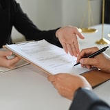 Cropped view of client signing contract or legal papers with lawyer. Law services concept.