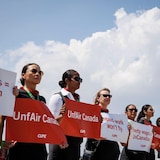 Flight attendants holding signs saying 'UnfAir Canada', 'Poverty wages = UnCanadian' and 'Unpaid work won't fly'.