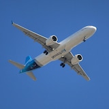 Un avion vole dans le ciel.