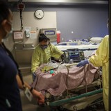 مصاب بالـ’’كوفيد - 19‘‘ محاط بأفراد من الجسم الطبي في أحد مستشفيات كالغاري في صيف 2021. 