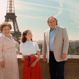 Les trois personnes posent devant la tour Eiffel, à Paris.