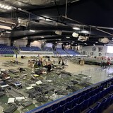Beds are being set up in an arena.