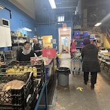 Deux employés et une cliente de la Banque alimentaire de Richmond dans l'entrepôt.