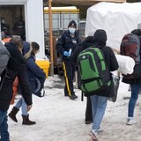 A family of asylum seekers from Colombia is met by RCMP officers after crossing the border at Roxham Road into Canada on February 9, 2023. Sources tell Radio-Canada the Canadian and American governments have reached a deal which would shut down the irregular border crossing. (Ryan Remiorz/The Canadian Press)