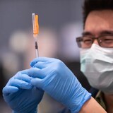 A coronavirus vaccine is prepared at a clinic in Vancouver earlier this year. The bivalent booster shots are now available to adults across provinces in Canada.