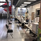 Un bureau de vote désert : des chaises vides sont alignées en face de tables sur lesquelles sont posées des urnes.