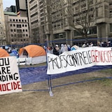 Estudiantes muestran pancartas que dicen "Ustedes están financiando el genocidio" y "Profesores contra el genocidio".
