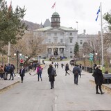 De nombreux passants marchent devant le bâtiment principal de l’Université McGill.