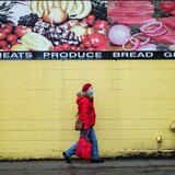A person is pictured walking past a grocery store sign promoting food products in downtown Vancouver, B.C., on Wednesday, Jan. 19, 2022. Canada's official inflation rate rose at a 6.8 per cent annual pace in April. 