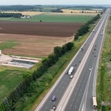 Vue aérienne de terres agricoles en bordure d'une autoroute. 