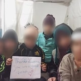 صورة قديمة للأطفال الكنديين الستة في مخيم اعتقالهم في شمال شرق سوريا وهم يحملون لافتة يشكرون فيها محامي والدتهم لورانس غرينسبون على جهوده من أجل إحضارهم إلى كندا.