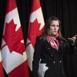 La ministre Freeland devant le drapeau canadien lors d'un point de presse.