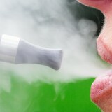 Une femme fume une cigarette électronique.
