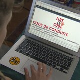 Une femme lit le code de conduite qui apparait à l'écran de son ordinateur portable.