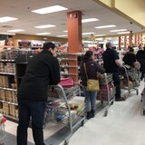 Los clientes hacen cola en un supermercado.