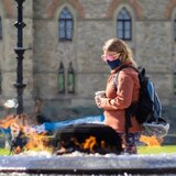 A person in sunglasses and a mask walks past the Centennial Flame in Ottawa on Sept. 30, 2021, during the COVID-19 pandemic. (Trevor Pritchard/CBC)