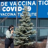 A woman walks past a COVID-19 vaccination clinic in Montreal in this photo taken April 6. New research published Monday in the Canadian Medical Association Journal credits Canada's strong COVID-19 performance to restrictive and persistent public health measures, as well as a successful vaccination campaign. (Ryan Remiorz/The Canadian Press)