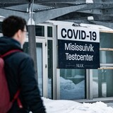 A man walks past a sign for a Covid-19 test centre in Nuuk, Greenland.