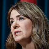 Closeup of Danielle Smith speaking into a microphone.