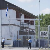 Guardias de seguridad junto a las puertas del centro de detención de migrantes de la Agencia de Servicios Fronterizos de Canadá  en Laval, Quebec.