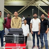 Un jeune homme avec des bagages à l'aéroport, entouré par d'autres personnes.